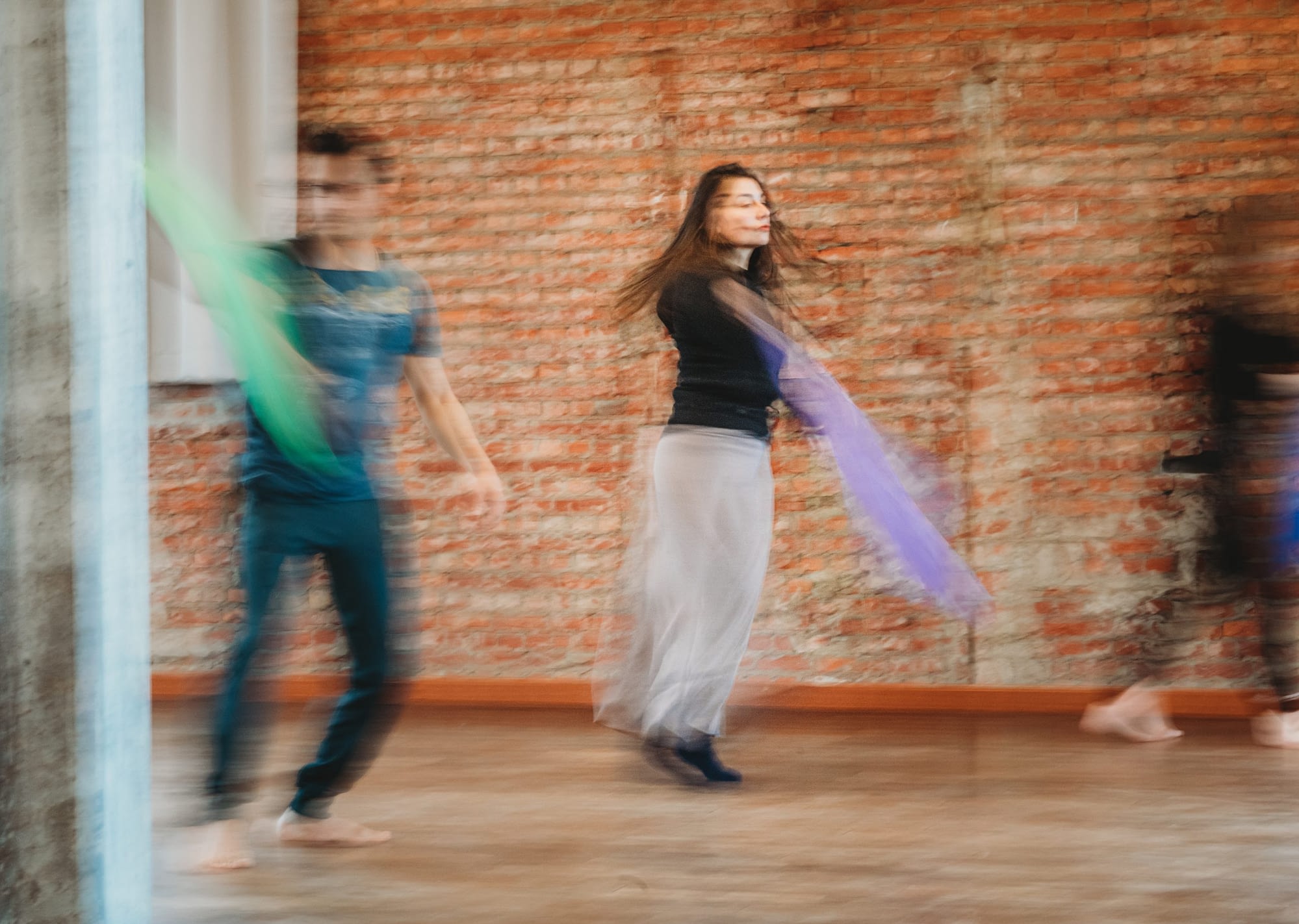 Jongvolwassen cliënten experimenteren met dansmateriaal in danstherapeutische sessie.